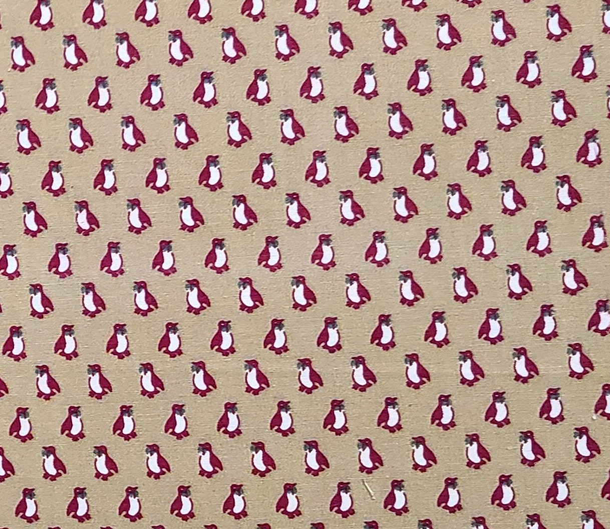 An Ameritex Fabric - Tan Fabric / Red Penguin Print