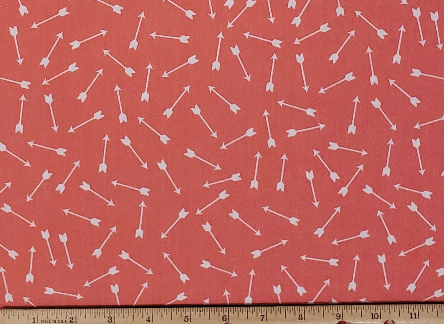 JoAnn Fabric - Coral Fabric / Tossed White Arrow Pattern