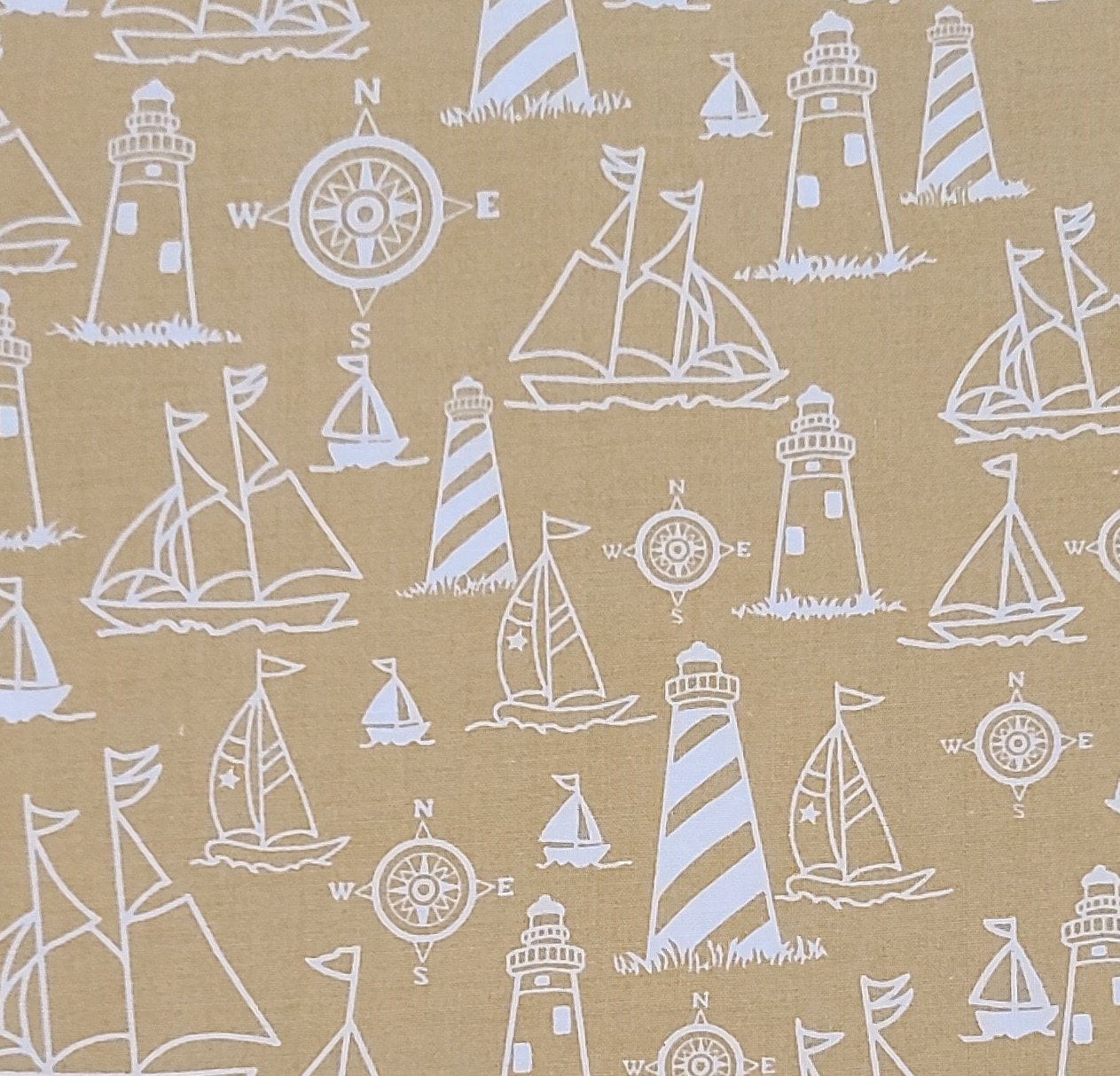 Marcus Brothers Textiles Inc - Golden Tan Fabric / White Lighthouse, Sailboat and Windrows Pattern.